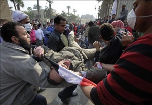 Manifestantes desalojan a un compañero alcanzado por una bomba de gas lacrimógeno durante los enfrentamientos entre la policía y los manifestantes en la plaza Tahrir de El Cairo (Egipto), hoy, miércoles 23 de noviembre de 2011. EFE
